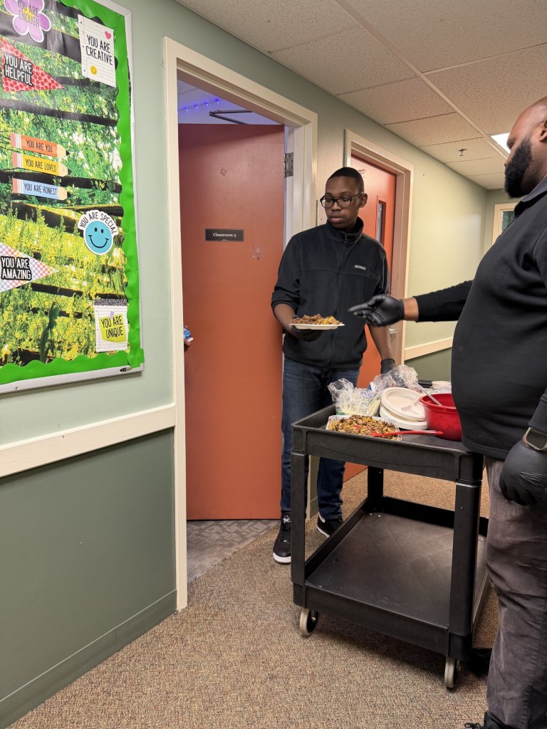 Oliver moving water containers as part of a transition skills activity at High Road School of Massachusetts.