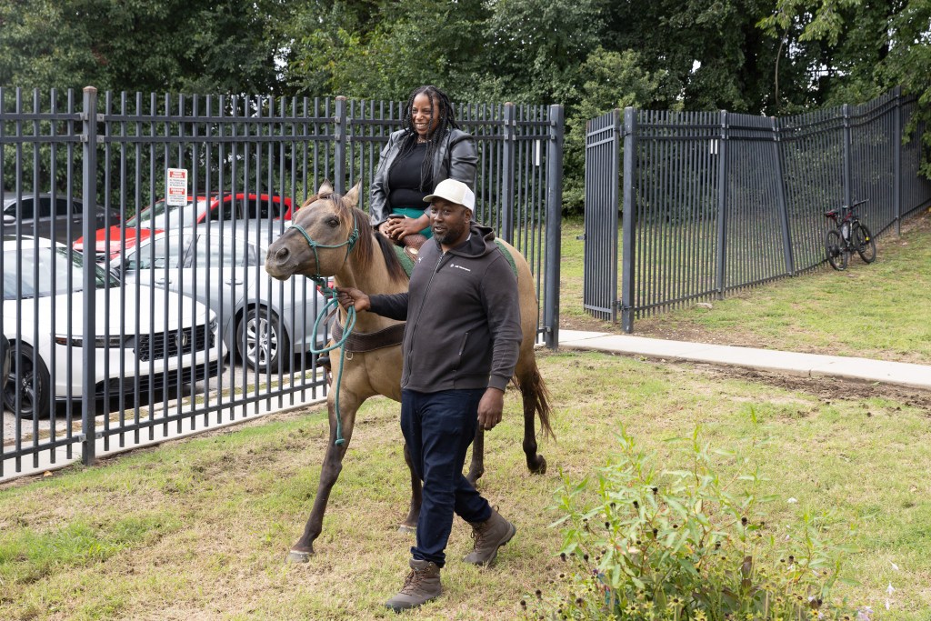 Un miembro del personal de Achieve Academy East montando a caballo durante una visita escolar de Concrete Cowboys en Filadelfia.