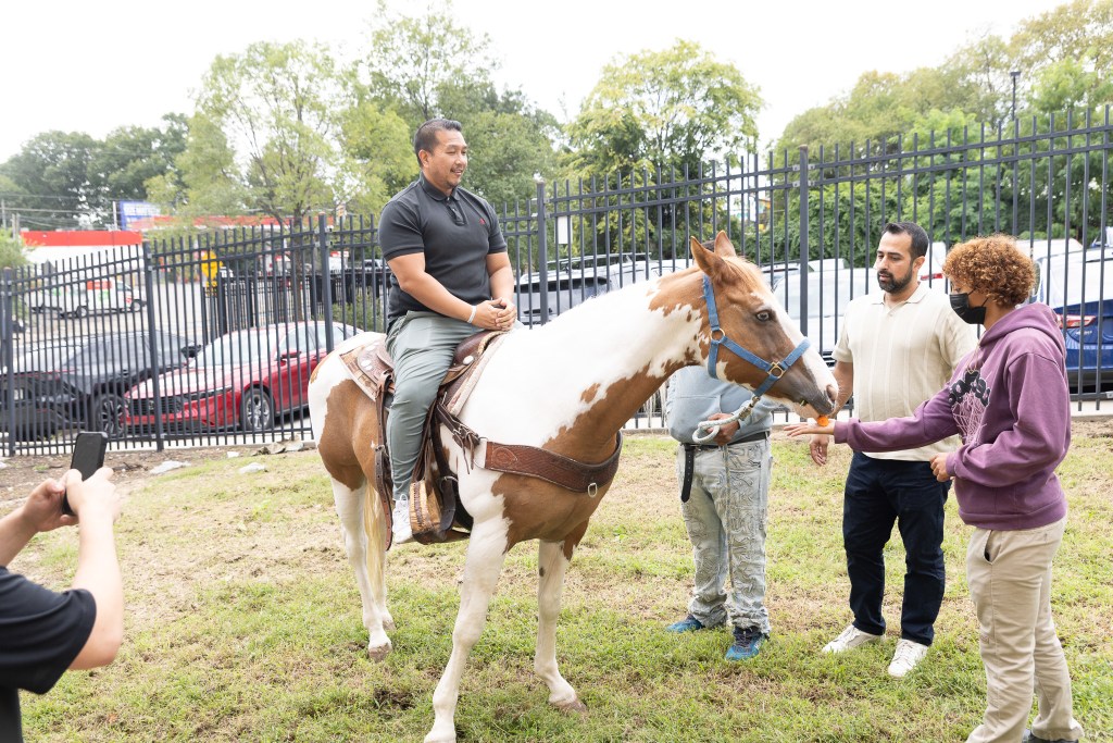 Un miembro del personal de Achieve Academy East montando a caballo mientras los alumnos y el personal participan en la visita escolar «Concrete Cowboys».