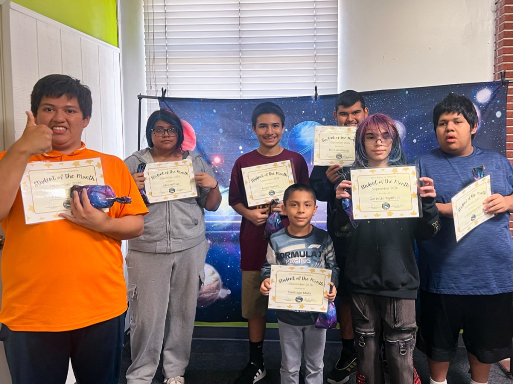 Sierra School of Alhambra students holding September Student of the Month certificates during a school recognition celebration.