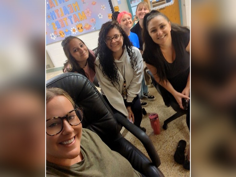 Staff members smile together for a group photo inside High Road School of the South Suburbs.