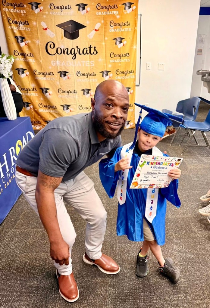 Carl Blackmon celebrates with a young student during a graduation ceremony at High Road School of Santa Rosa.