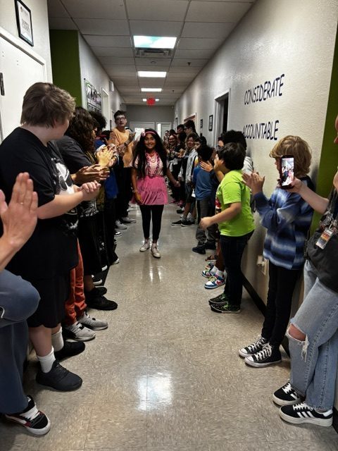 Un alumno de la Sierra School de Gilbert atraviesa el Victory Tunnel mientras sus compañeros y el personal le aplauden.