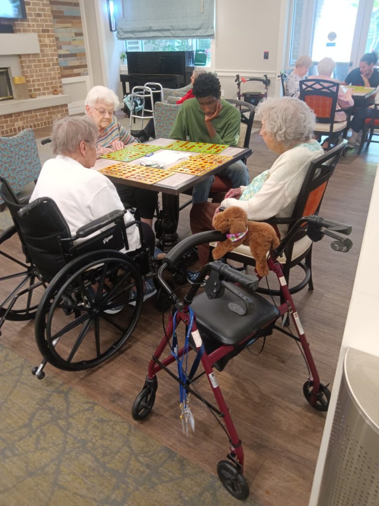 High Road student participating in a bingo activity with Oak Crest residents during a volunteer visit.