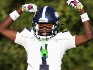 DonTaye Day-Thompson, alumno de la Seashore Leadership Academy y jugador de fútbol americano del instituto Atlantic City High School, que lleva el dorsal número 1, celebra con los brazos en alto mientras un compañero lo levanta en volandas sobre el campo.