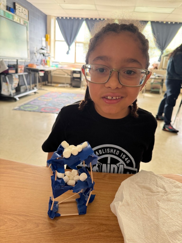High Road School of Hartford student Jose displaying a classroom project made with craft sticks, tape and marshmallows.