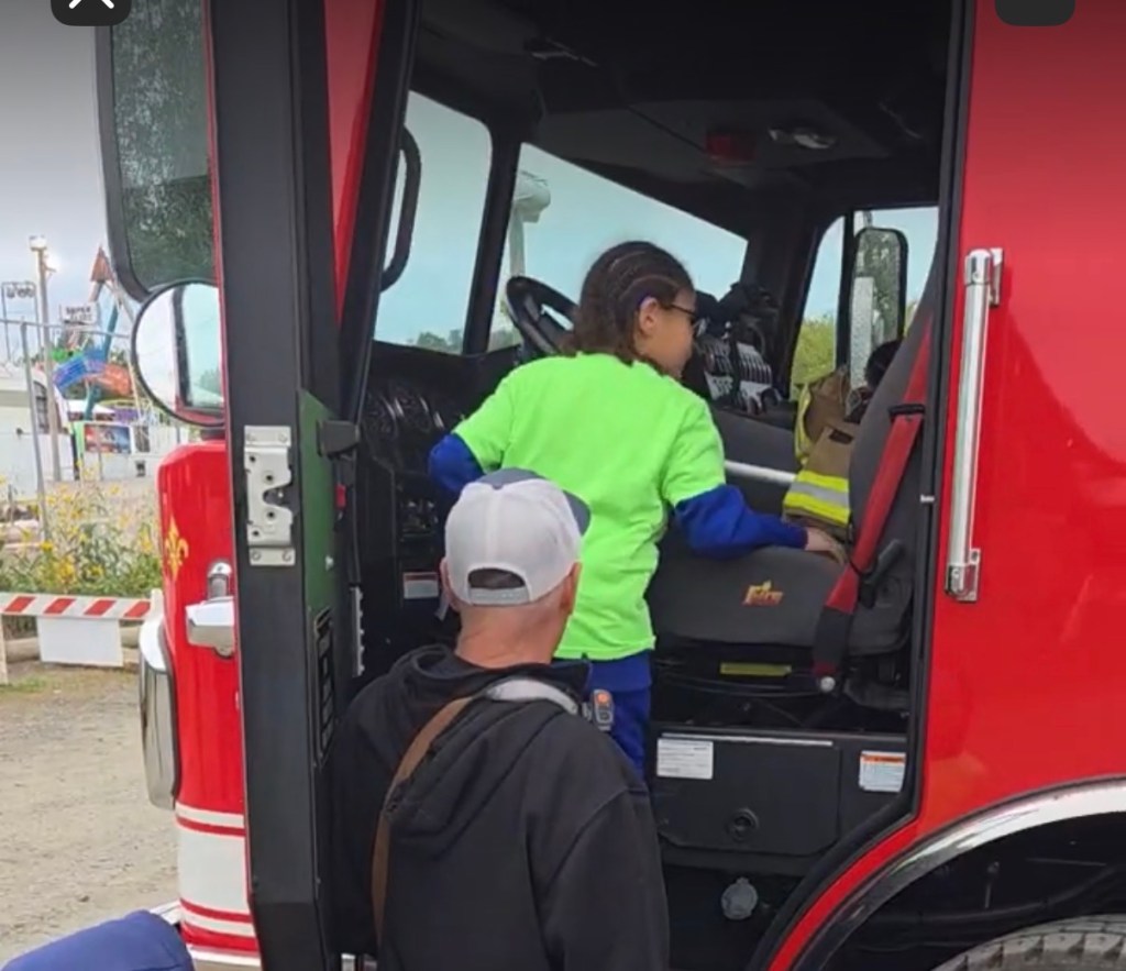 Jose exploring the inside of a fire truck during the High Road School of Hartford trip to the Durham Fair.