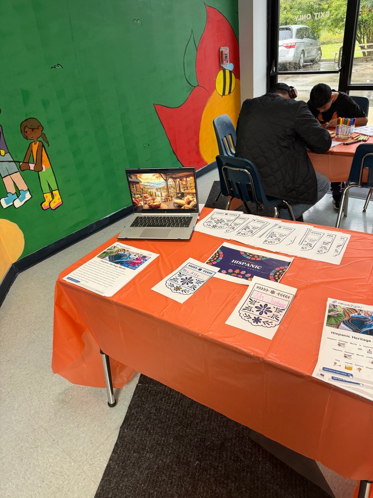 Mesa de la jornada de puertas abiertas de la escuela High Road de Hoffman Estates, en la que se presentan las actividades del Mes de la Herencia Hispana y materiales para los alumnos.