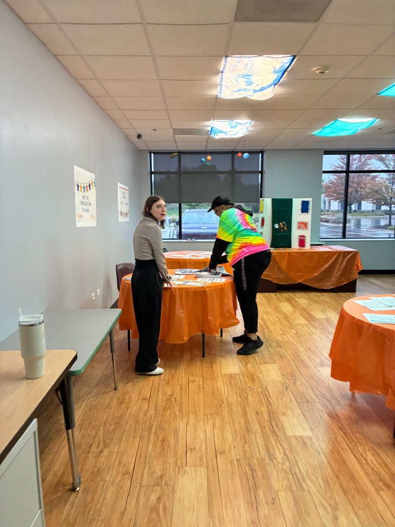 El personal prepara mesas informativas para las familias durante la jornada de puertas abiertas del colegio High Road de Hoffman Estates.
