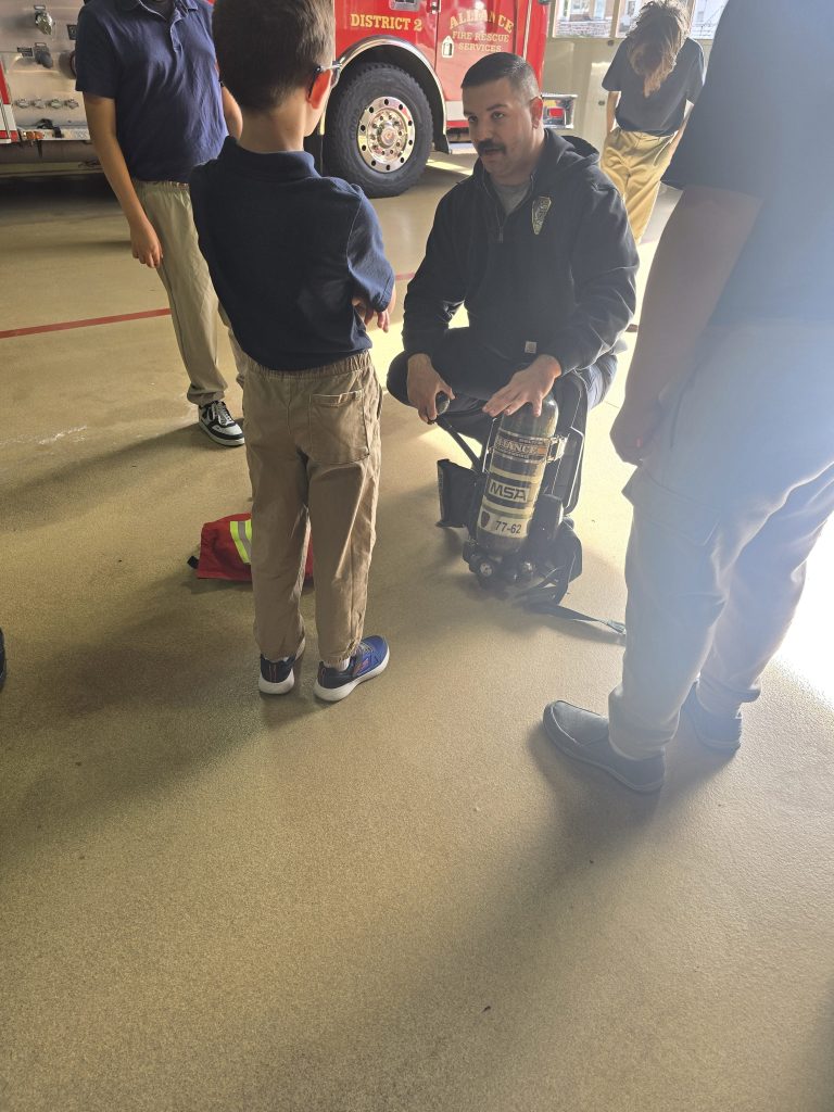 Un alumno de la High Road School de York se prueba el equipo de bombero durante una visita al cuerpo de bomberos Alliance Fire Rescue.