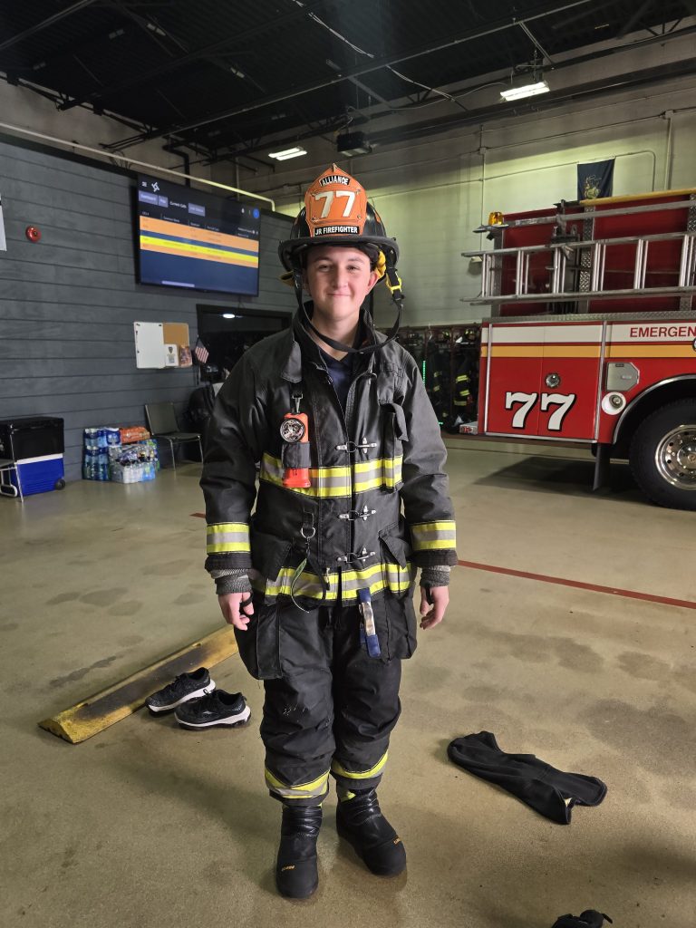 Un alumno de la High Road School de York luce el equipo de intervención de los bomberos durante una actividad de aprendizaje práctico.