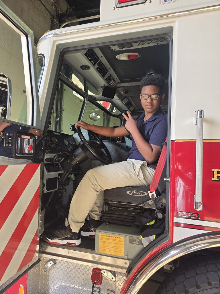 Un alumno de la High Road School de York se sienta en el asiento del conductor de un camión de Alliance Fire Rescue.
