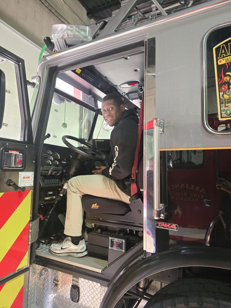 Un alumno de la High Road School de York se sienta dentro de un camión de bomberos de Alliance Fire Rescue durante una visita a la estación.