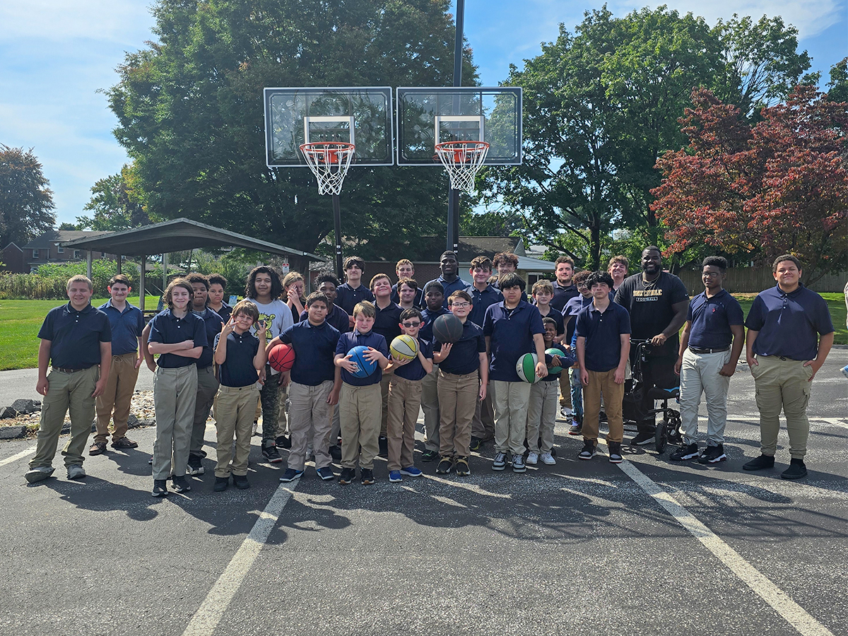 Los alumnos y el personal de la High Road School de York posan junto a las nuevas canastas de baloncesto donadas por Powder Coating Specialists.