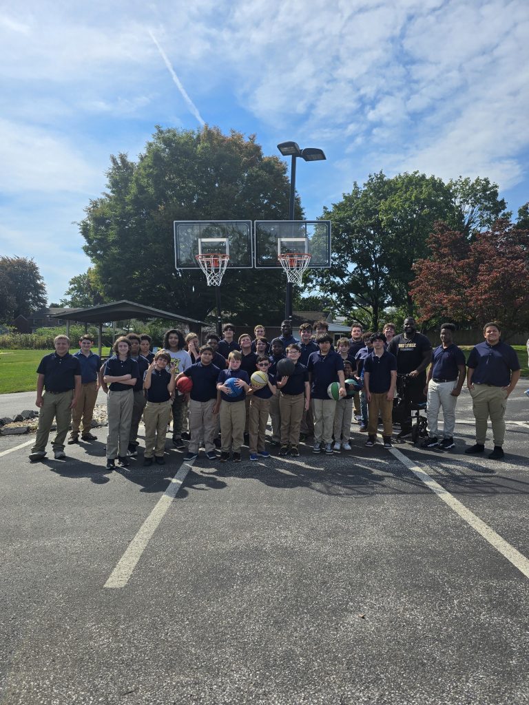 Los alumnos y el personal de la High Road School de York posan junto a las nuevas canastas de baloncesto donadas por Powder Coating Specialists.