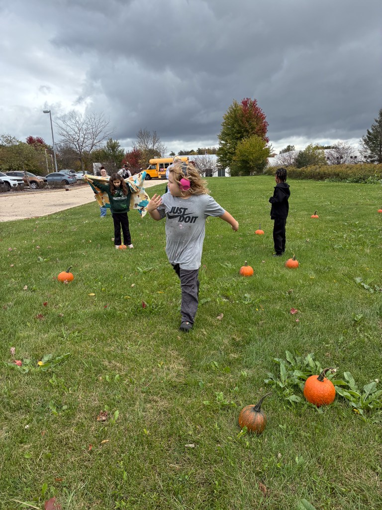High Road School of Hoffman Estates students explore an outdoor pumpkin patch during Fall Fest, with one student running between pumpkins.