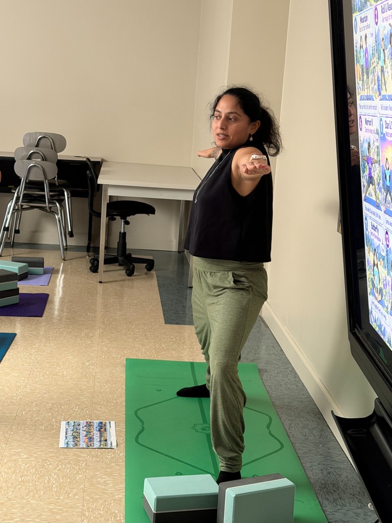 Program Director Tara Chander demonstrates a yoga pose while leading students through a Friday yoga session at High Road School of Anne Arundel County.