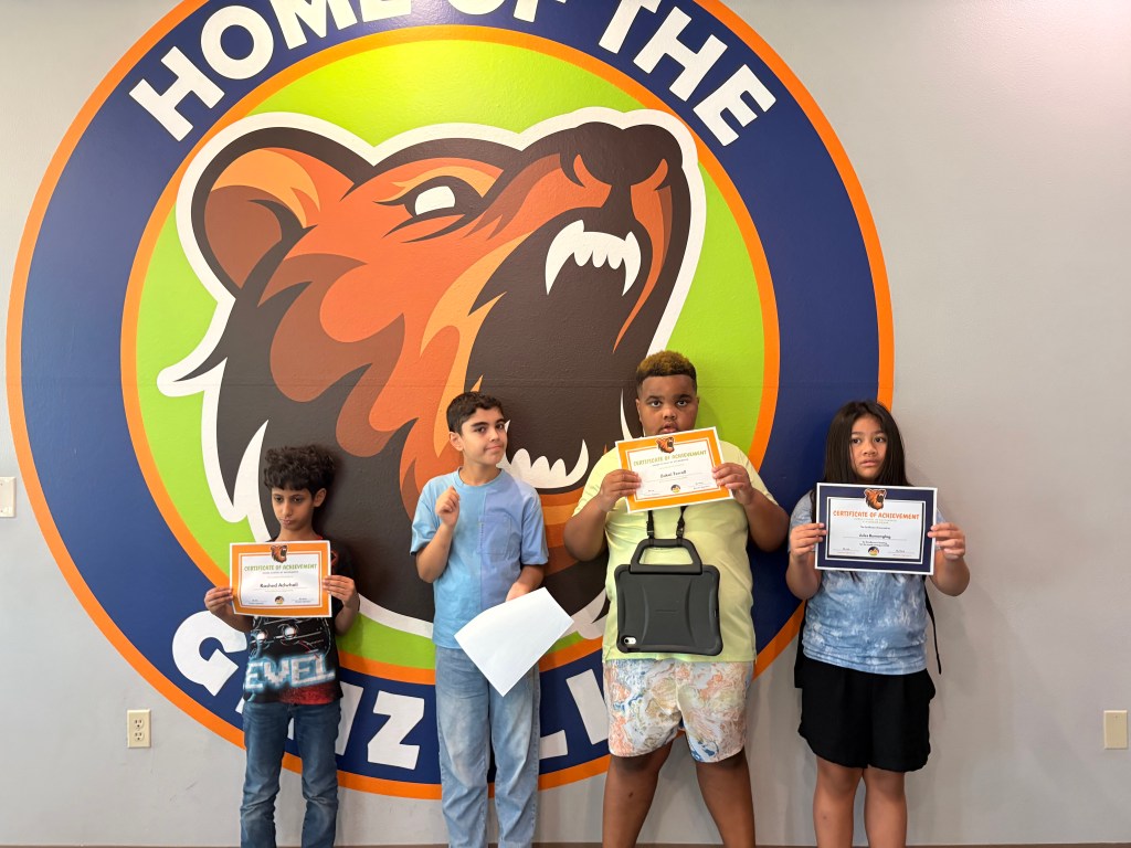 Sierra School of Sacramento students holding Grizzly Awards in recognition of their achievements.