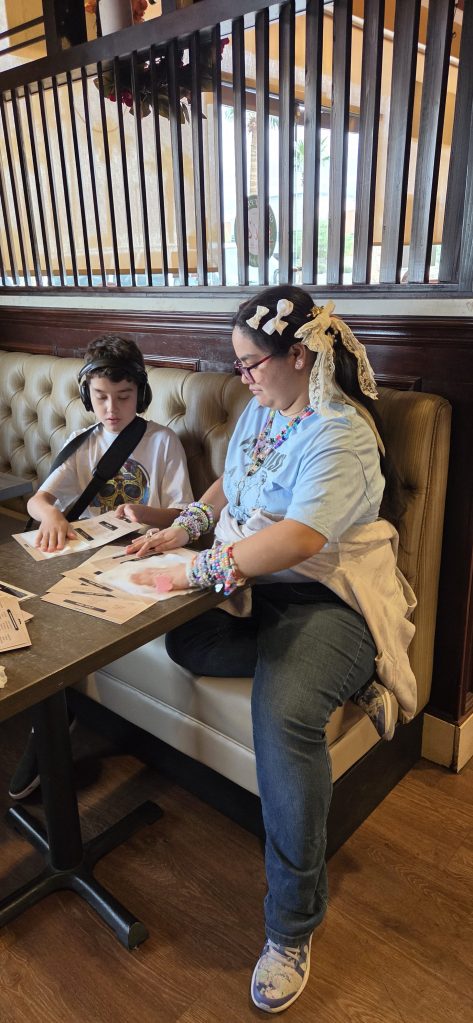 Sierra School of Gilbert student and staff member review restaurant materials together at Sal's Gilbert Pizza.