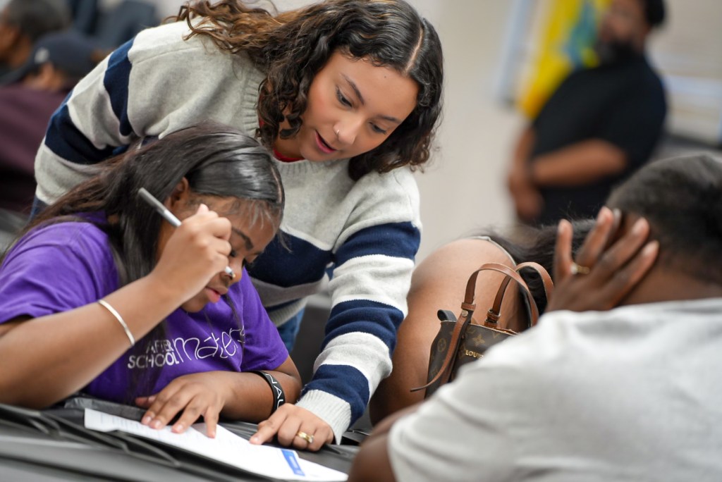 Excel Academy of Roseland staff member supporting a student during the event.