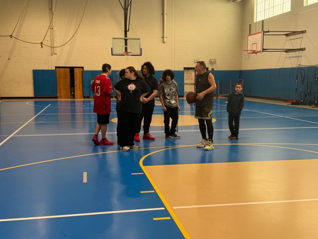 Students from the High Road Schools of Hartford participate in the Dave Hopla Shooting Clinic on a basketball court.